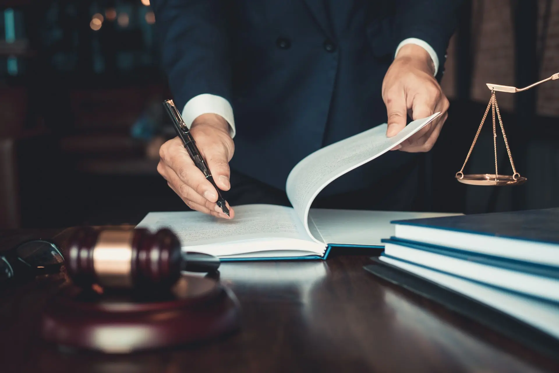 A person in suit and tie writing on paper.